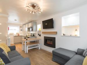 a living room with a couch and a fireplace at One Beckside Cottage in Staithes