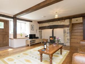 a living room with a stone fireplace and a table at The Farmhouse At Higher Westwater in Axminster