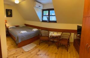 卡齊米日－多爾尼的住宿－Pokoje Gościnne Joanna，卧室配有一张床和一张桌子及椅子