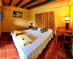 a bedroom with a bed and a table and a window at Hospedaje Pance Arí Munani Reserva Natural in Cali