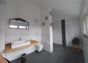 a white bathroom with a sink and a toilet at Art Apart Stuttgart in Rutesheim