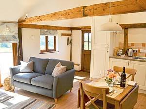 a living room with a blue couch and a table at Little Midge Barn in Ashburnham