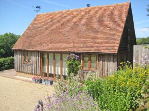 uma pequena casa de madeira com telhado em Little Midge Barn em Ashburnham
