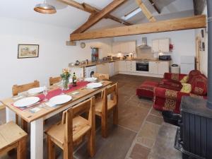 cocina y sala de estar con mesa de madera y sillas en Bramble Cottage - 27978, en Whalley