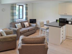 a kitchen and living room with a couch and a table at Coastal Retreat in Felpham