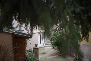 ein weißes Haus mit einer Tür und einem Baum in der Unterkunft Tanis Apartments in Niš