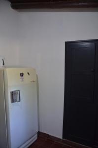 a white refrigerator in a room with a black door at Rios libres in Potrerillos