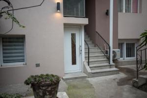 ein Haus mit einer weißen Tür und einer Treppe in der Unterkunft Tanis Apartments in Niš