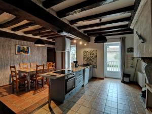 een keuken en eetkamer met een tafel en stoelen bij Aux Acacias in Braye-sous-Faye