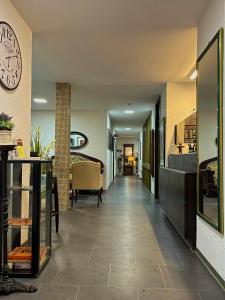 a long hallway with a clock on the wall at Hotel Brunnenhof in Bad Nauheim