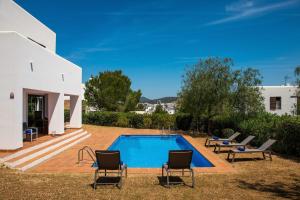 einen Pool in einem Garten mit Stühlen und einem Haus in der Unterkunft Can Terra con piscina in San Jose de sa Talaia