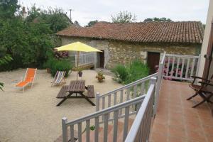 a patio with an umbrella and a table and chairs at Aux Acacias in Braye-sous-Faye