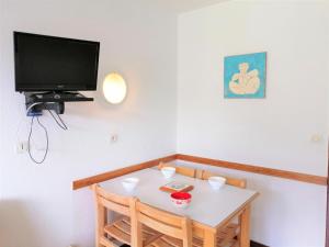 ein kleines Esszimmer mit einem Tisch und einem TV in der Unterkunft Studio Morillon 1100, 1 pièce, 4 personnes - FR-1-412-3 in Morillon