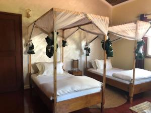 2 łóżka z baldachimem w sypialni w obiekcie Rudi House w mieście Msaranga
