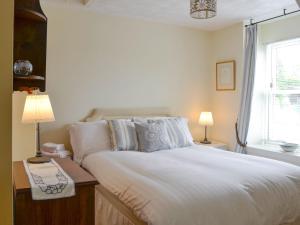 a bedroom with a large white bed and a window at Kerloch View in Banchory