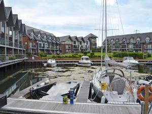 a boat is docked at a marina with houses at Toad Hall in Osborne