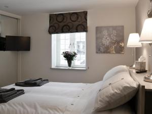 a bedroom with a white bed and a window at Back O The Beck in Skipton