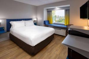 um quarto de hotel com uma cama grande e uma janela em Microtel Inn and Suites - Salisbury em Salisbury