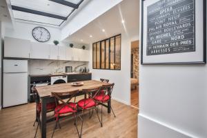 kuchnia i jadalnia z drewnianym stołem i krzesłami w obiekcie 2.Luxueux Duplex 6/8pers/Full Equipped/République w Paryżu