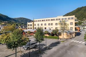 ein Gebäude mit einem Auto auf einem Parkplatz in der Unterkunft Best Western Laegreid Hotell in Sogndal