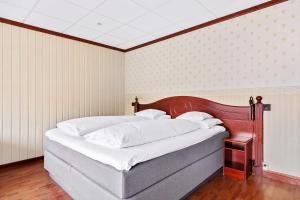 a bedroom with a large bed with a wooden headboard at Best Western Laegreid Hotell in Sogndal