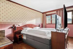 a bedroom with a large bed and a television at Best Western Laegreid Hotell in Sogndal
