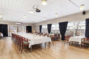 un comedor con mesas y sillas blancas y ventanas en Best Western Tingvold Park Hotel en Steinkjer