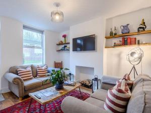 a living room with two couches and a tv at Magna Carta Cottage in Lincolnshire