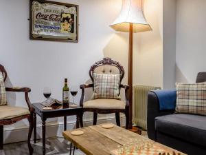 a living room with a couch and a table with wine glasses at Magna Carta Cottage in Lincolnshire