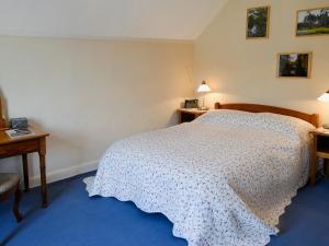 a bedroom with a bed with a white bedspread at Low Fold Cottage in Stainforth