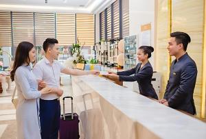 um grupo de pessoas em pé em torno de um balcão em uma loja em Phuc Thanh Luxury Hotel by THG em Da Nang