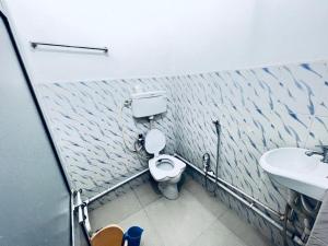 a bathroom with a toilet and a sink at HOTEL RAJGIR INTERNATIONAL in Rājgīr