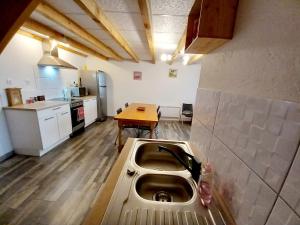 eine Küche mit einem Waschbecken in der Mitte eines Zimmers in der Unterkunft Maison de ville au cœur du quartier historique in Oloron-Sainte-Marie