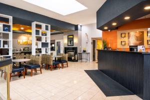 Comfort Hotel & Suites في بيتربورو: مطعم مع بار وغرفة طعام