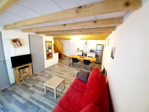 オロロン・サント・マリーにあるMaison de ville au cœur du quartier historiqueの赤いソファとテーブルのあるリビングルーム