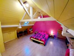 ein Schlafzimmer mit einer rosa Wand und einem Bett in der Unterkunft Maison de ville au cœur du quartier historique in Oloron-Sainte-Marie