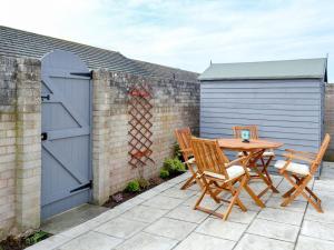 a patio with a table and two chairs and a garage at Gwynt Y Mr in Tywyn