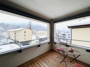 a balcony with a table and two large windows at New building with balcony closecentrefreeparkingsmarttv in St. Gallen