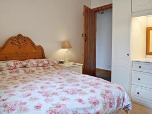 a bedroom with a bed with a floral bedspread at Tremafon in Barmouth