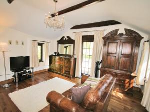 a living room with a couch and a television at Quantock Hideaway in Nether Stowey