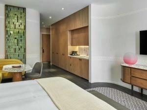 a bedroom with a bed and a desk and a tv at SLS LUX Brickell in Miami