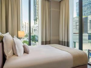 a bedroom with a large bed with a large window at SLS LUX Brickell in Miami