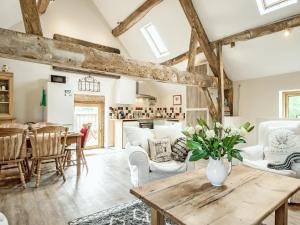 a kitchen and living room with wooden beams at The West Barn in Hanley Castle