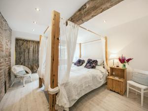 - une chambre avec un lit à baldaquin dans l'établissement The West Barn, à Hanley Castle