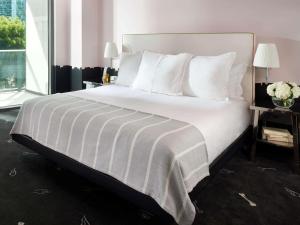 a bedroom with a large bed with white sheets and pillows at SLS Brickell in Miami