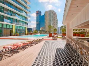 a swimming pool with lounge chairs and a building at SLS Brickell in Miami