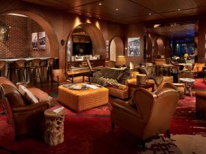 a living room with leather furniture and a bar at SLS Brickell in Miami