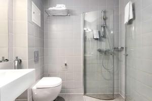 a bathroom with a shower and a toilet and a sink at Saga Hotel Oslo, WorldHotels Crafted in Oslo