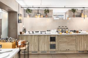 a kitchen with wooden cabinets and a counter top at Saga Hotel Oslo, WorldHotels Crafted in Oslo