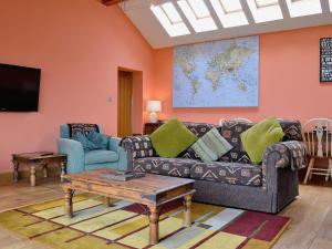 a living room with a couch and a tv at The Water Tower in Auchmithie